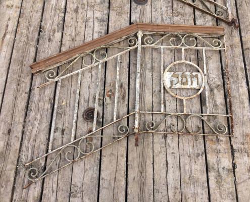 Antique wrought iron stair rail with wooden rail and Hebrew writing