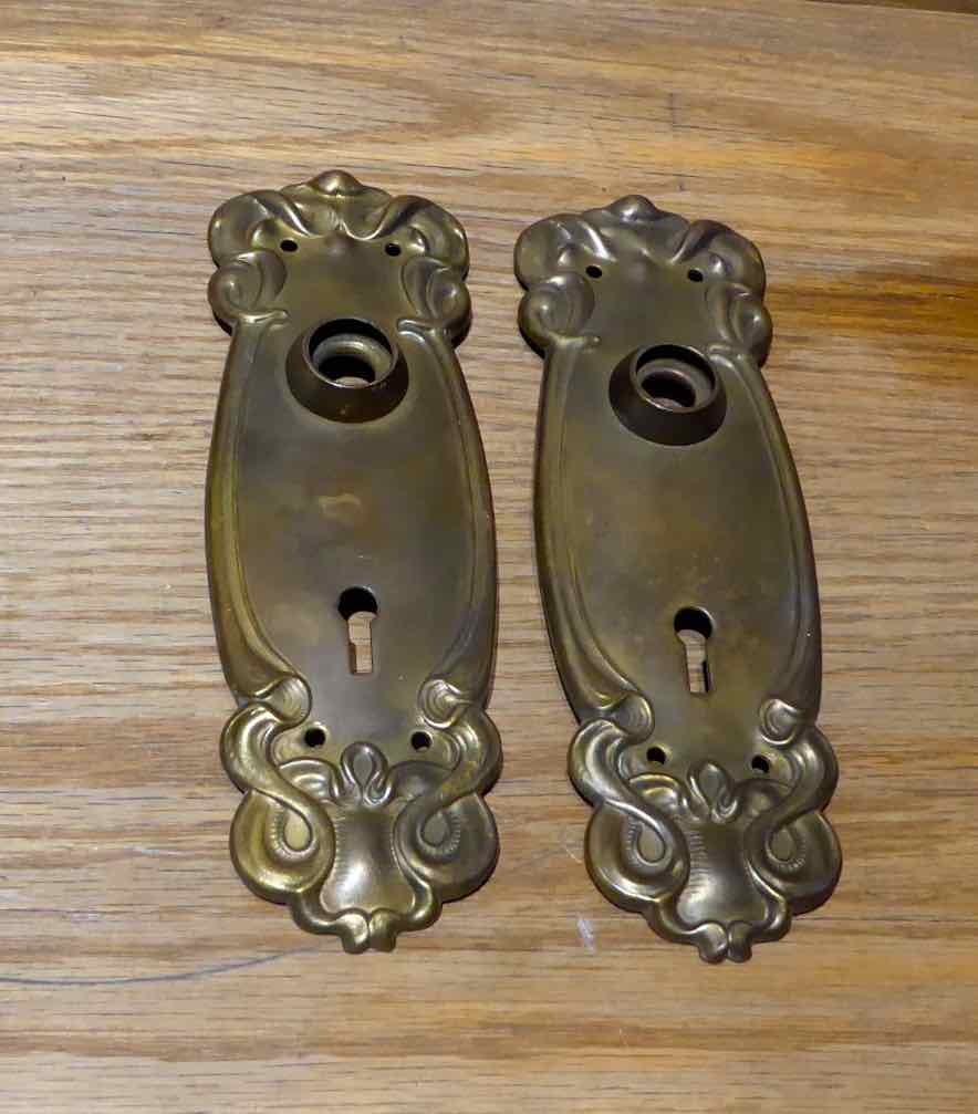 Closeup of backplates - Solid brass antique Victorian passage set. Set includes brass patterned doorknobs and brass patterned backplates. 