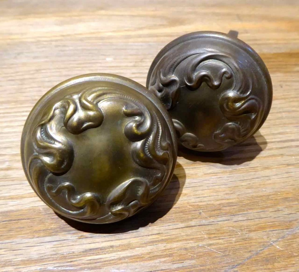 Closeup of doorknobs - Solid brass antique Victorian passage set. Set includes brass patterned doorknobs and brass patterned backplates. 