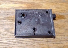Antique Cast Iron rim lock, manufactured and signed on both sides with B.L.W. shield logo. Lock has a night latch for privacy without using the keyed deadbolt, and has reversible handing.