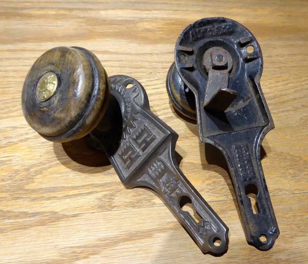 Closeup of wooden door handles - Origianl Victorian style cast iron passage set with wood door knobs and cast iron gravity lock. Features wood doorknobs built into the backplates.